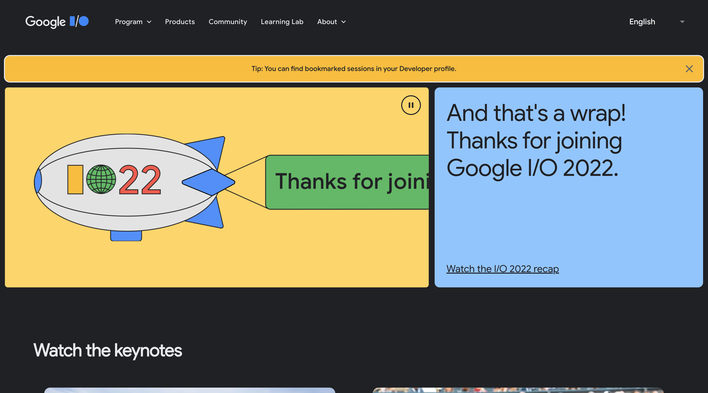 Screenshot of the Google I/O 2022 home page. The header contains the Google I/O logo, the main navigation, and a language selector. The hero section contains an illustration of a blimp with 'IO22' written on the side. The blimp is towing a banner that says 'Thanks for joining'.